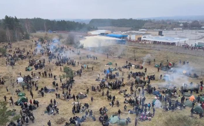مهاجرون يقفون وسط الدخان على الحدود البيلاروسية البولندية