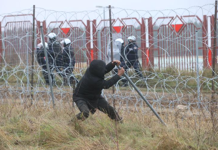 مهاجرون أمام السياج على الحدود البيلاروسية البولندية
