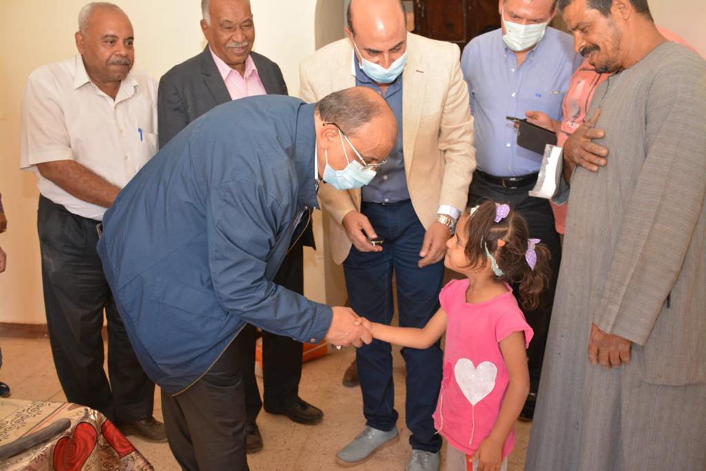 وزير التنمية المحلية مع طفلة فى المناطق المتضررة من السيول بأسوان