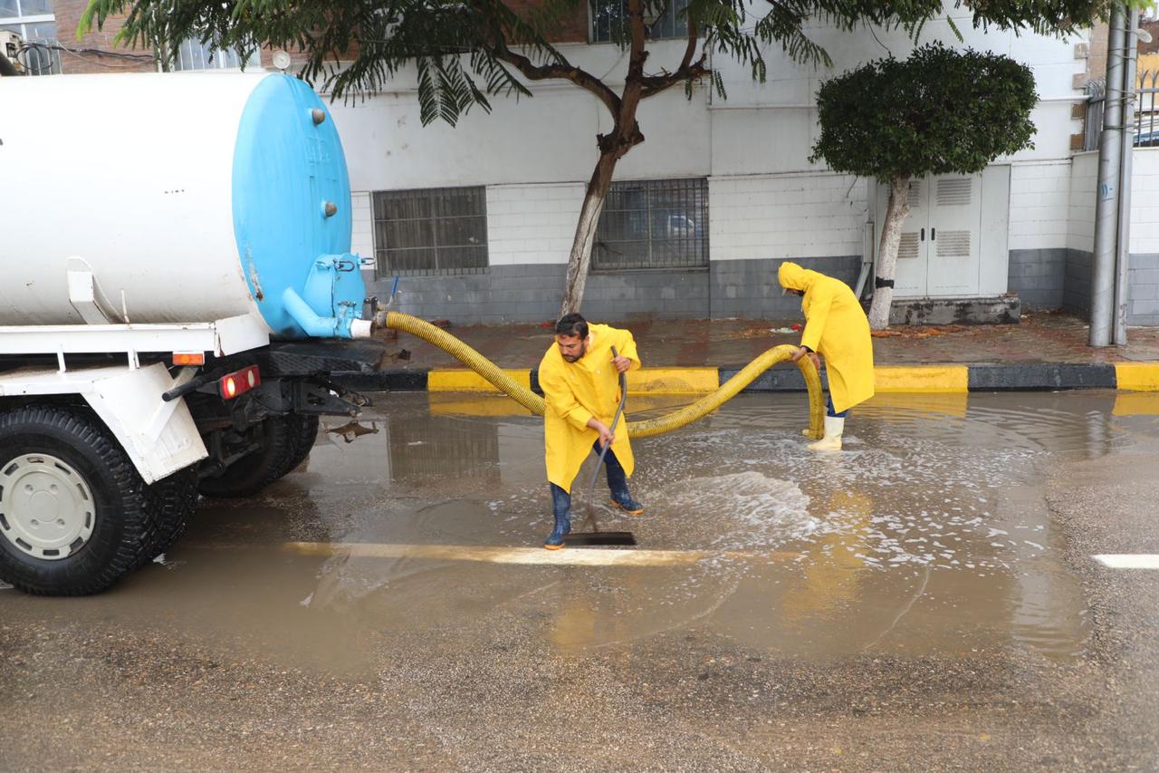 رجال المحليات أثناء شفط تراكمات مياه الأمطار