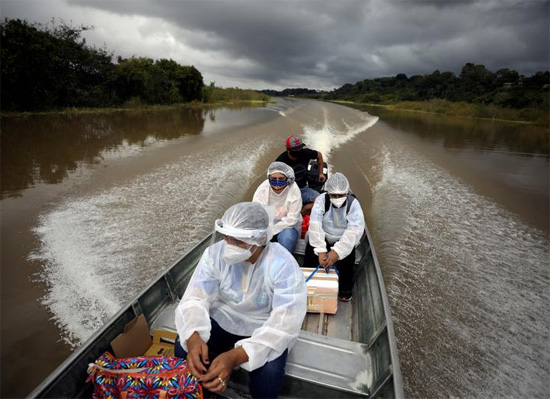 يسافر العاملون في مجال الصحة بالبلدية على متن قارب على طول ضفاف نهر سوليموس فى البرازيل