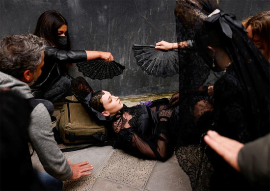 عارضة أزياء مستلقية على الأرض بعد أن عانت من الدوار قبل بدء حدث لعرض أزياء المانتيلا التقليدية فى إسبانيا