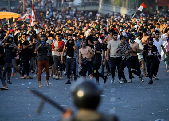 متظاهرون يواجهون قوات الأمن خلال مظاهرة مناهضة للحكومة في بغداد