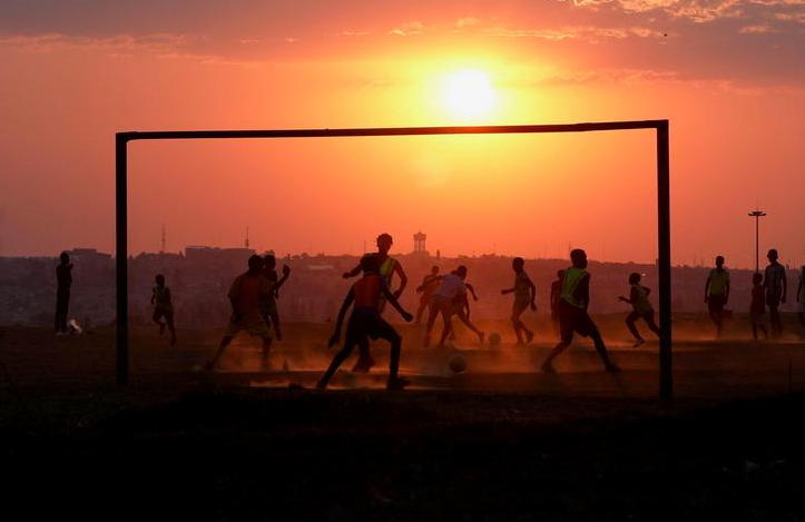 السكان المحليون يلعبون كرة القدم في سويتو بجنوب إفريقيا