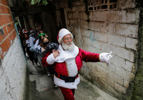 رجل يرتدي زي بابا نويل يشارك في توزيع لعب عيد الميلاد نظمته مجموعة صحفيين فنزويليين في كاراكاس