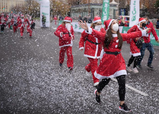 أشخاص يرتدون ملابس بابا نويل خلال سباق خيري لجمع الأموال لمساعدة ضحايا ثوران بركان كومبر