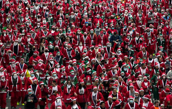 أشخاص يرتدون ملابس بابا نويل يشاركون في سباق خيري لجمع الأموال لمساعدة ضحايا ثوران بركان كومبر فيجا في مدريد إسبانيا