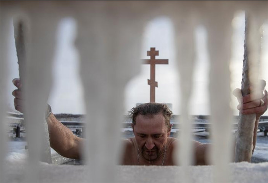 رجل يغطس في المياه الجليدية خلال الاحتفالات بعيد الغطاس للمسيحيين الأرثوذكس في موسكو