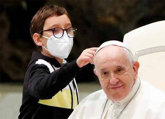 صبي يقترب من البابا فرانسيس خلال الاجتماع العام الأسبوعي في الفاتيكان