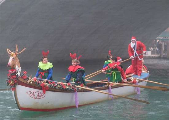 أشخاص يرتدون أزياء يتجادلون خلال سباق القوارب في عيد الميلاد في البندقيةإيطاليا