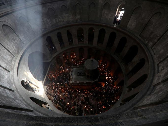 مصلون مسيحيون أرثوذكس يحضرون مراسم النار المقدسة وسط تخفيف قيود فيروس كورونا في كنيسة القيامة في البلدة القديمة بالقدس