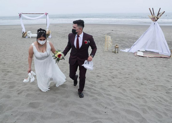 زوجان يغادران الشاطئ بعد زواجهما في حفل زفاف جماعي