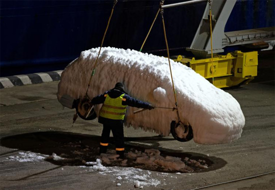 عامل يفرغ حمولة مركبة مغطاة بالجليد من سفينة في بحر اليابان
