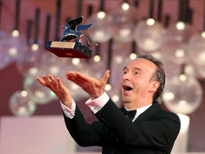 الممثل روبرتو بينيني يقف مع جائزة الأسد الذهبي على السجادة الحمراء خلال فى مهرجان البندقية السينمائي