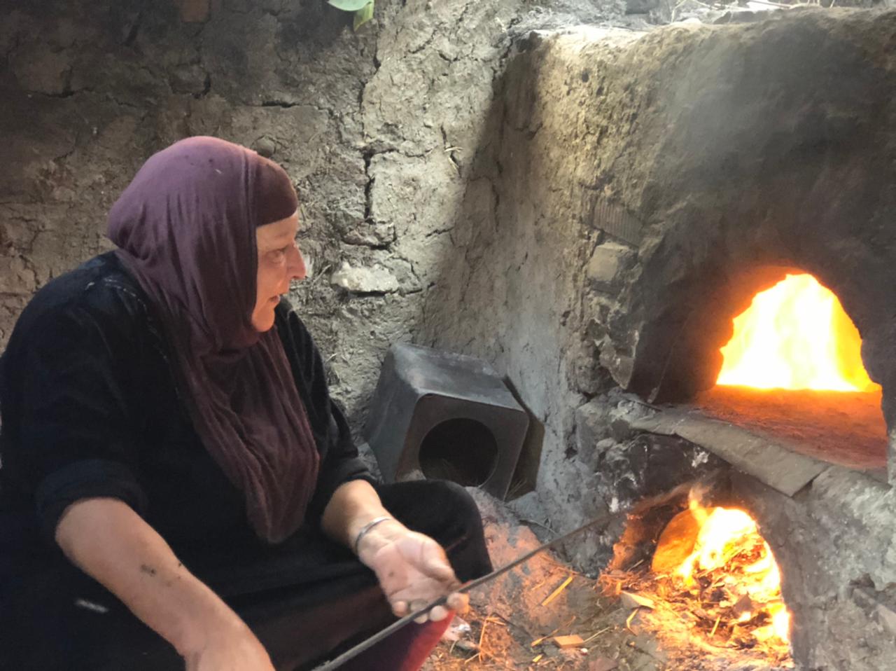 السيدة أنوار عبد الفتاح تخبز العيش الفلاحي في الفرن القش