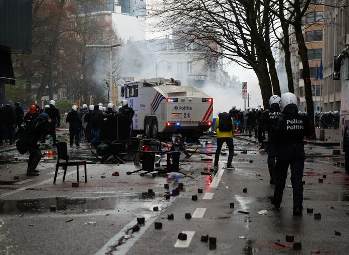 ضباط الشرطة يسيرون في الشارع خلال احتجاج على قيود الحكومة البلجيكية