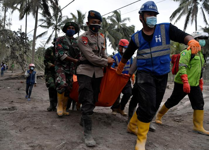 ضباط الإنقاذ الإندونيسيون يحملون جثة ضحية ثوران بركان جبل سيميرو