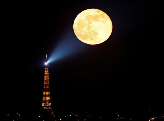 البدر المعروف باسم القمر الوردي الخارق يرتفع خلف برج إيفل في باريس
