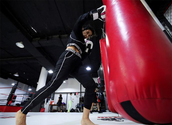 فتاة سعودية تتدرب بحقيبة ملاكمة