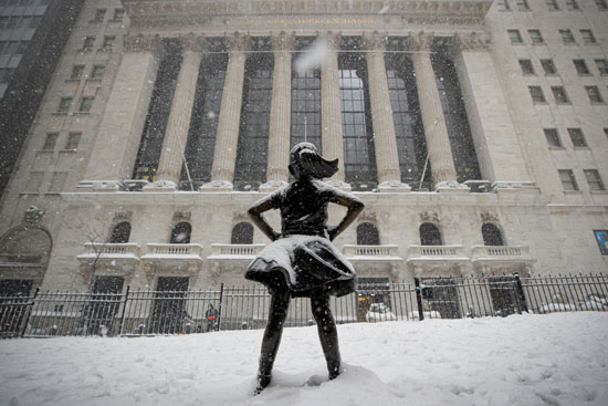 مواطنة أمريكية تقف أمام مقر محكمة بنيويورك بينما تحيطها الثلوج