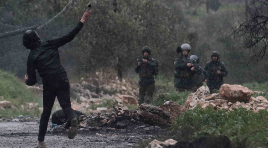 شاب يواجه قوات الاجتلال بالحجارة