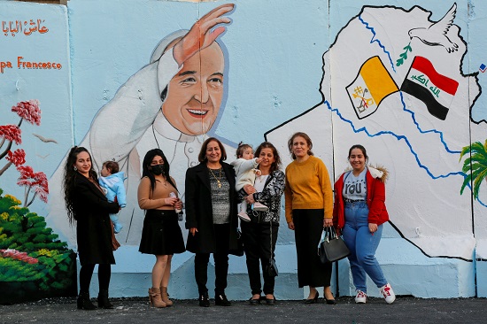 أسرة تلتقط صورة مع جدارية البابا