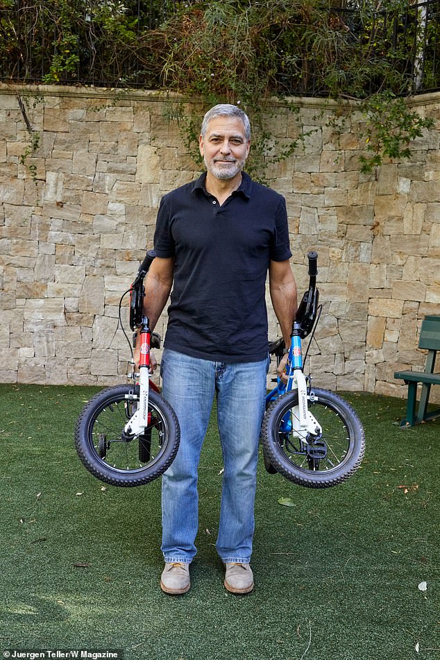جورج كلونى يحمل دراجات توأمه