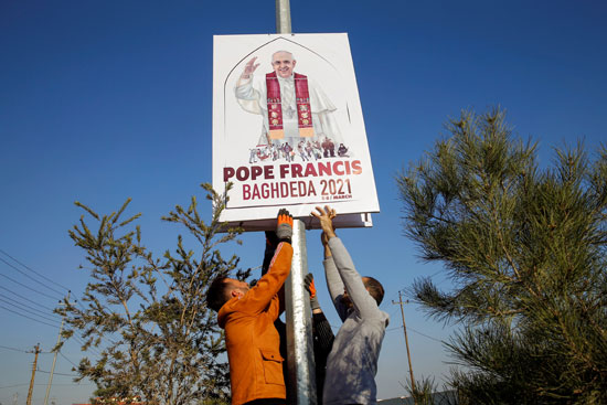 متطوعون يزينون الشوارع بصور البابا فرنسيس  قبل زيارته المقررة للعراق ، في قرقوش (2)