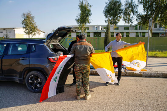 متطوعون مسيحيون يرفعون علم العراق والفاتيكان وهم يزينون الشوارع (2)