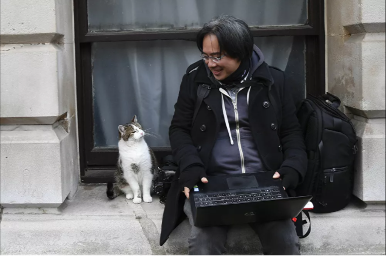 القط لاري يجلس بجوار مصور صحفي بمقر رئيس الوزراء البريطاني