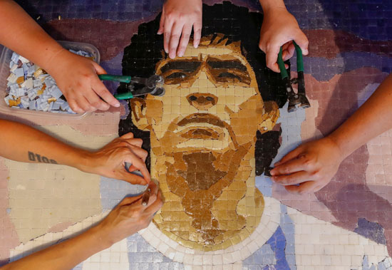  أعضاء منظمة كوماندو مارادونا الثقافية ، يقومون بإعداد فسيفساء تكريمًا لنجم كرة القدم الأرجنتيني الراحل  (3)