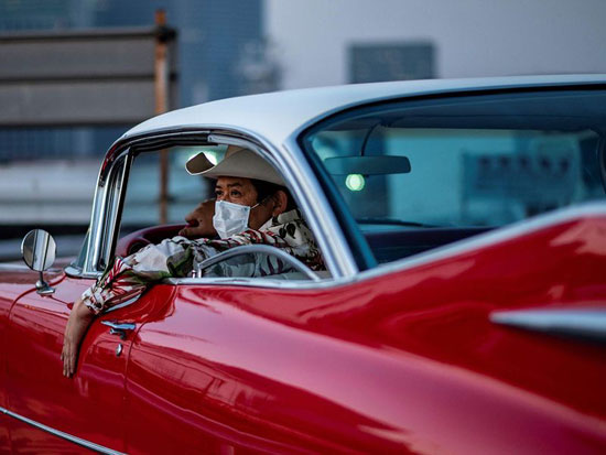 هيرويوكي وادا داخل سيارته الحمراء كاديلاك كوبيه دي فيل عام 1959