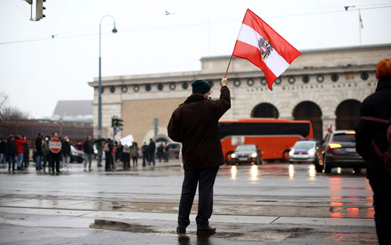 متظاهر يرفع علم النمسا