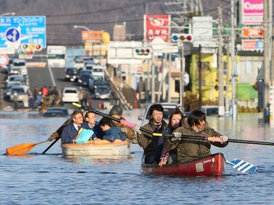 المواطنون يغادرون بقوارب صغيرة على طريق غمرته أمواج تسونامي