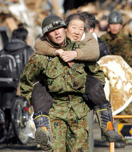 جندي يحمل امرأة مسنة على ظهره أثناء إجلاء المواطنين