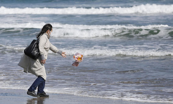 مواطنة تلقى باقة زهور بالبحر تكريما لذويها الراحلين