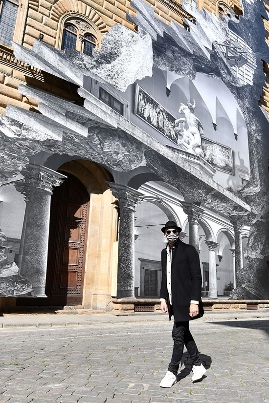 يقف الفنان الفرنسي المعاصر جي آر أمام تركيبته الفنية