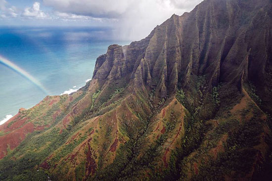 قوس قزح بين المحيط والجبال في هاواي
