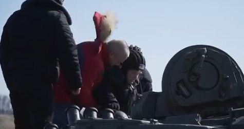 الجنود يساعدون العجوز لركوب الدبابة