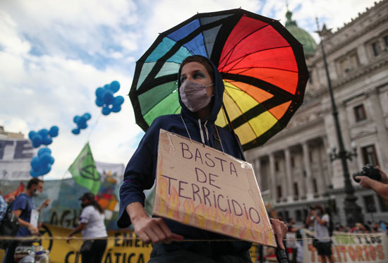 ناشطة تحمل لافتة مناهضة لسياسات تجاهل المناخ