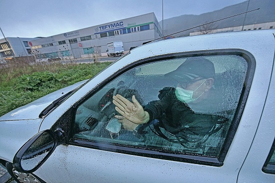 خافيير إيرور، 65 عامًا، ينظف نافذة سيارته عند هطول الأمطار