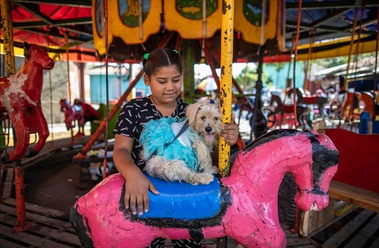 طفلة مع كلبها في مدينة الألعاب