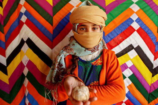 طفلة عراقية تقف لالتقاط صورة وهي تحمل كمأة