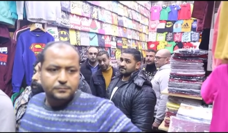 محمد امام داخل احد المحلات والجمهور فى انتظاره من أجل التقاط الصور معه