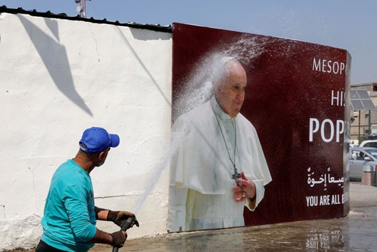 وضع المياه لتنظيف ملصق يحمل صورة البابا فرانسيس
