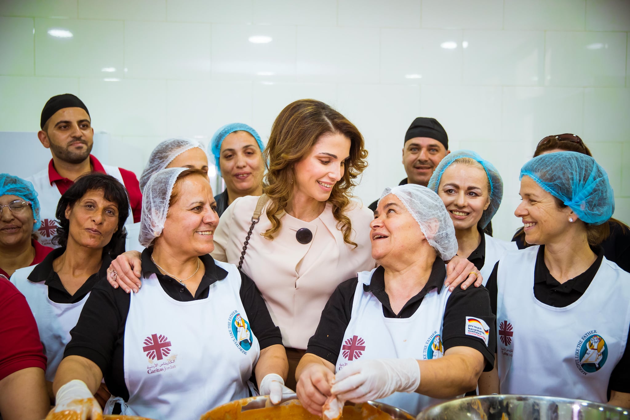 الملكلة رانيا تتوسط مجموعة من العاملات فى المجال الخدمى