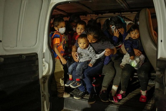 المهاجرون يجلسون داخل شاحنة لموظفي الحكومة المحلية ليتم نقلهم إلى ملجأ