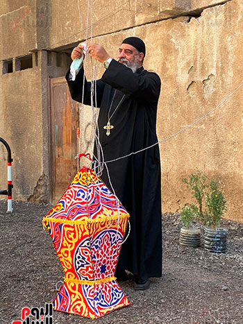 القمص يؤنس يعلق فانوس رمضان امام الكنيسة