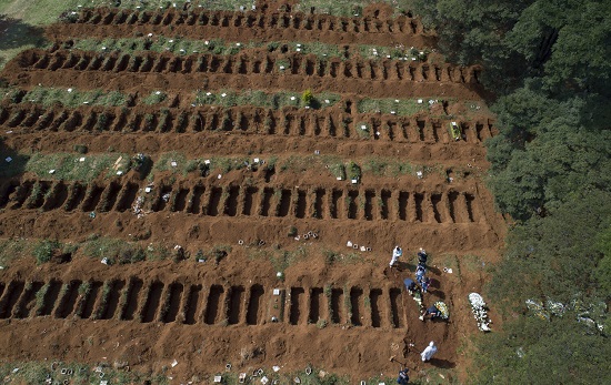 عمال مقبرة يرتدون ملابس واقية يدفنون شخصًا في البرازيل