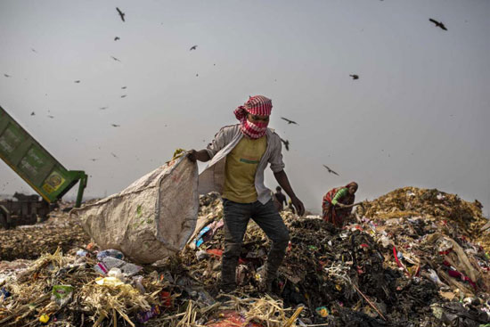 يبحث عمال القمامة عن المواد القابلة لإعادة التدوير في مكب النفايات
